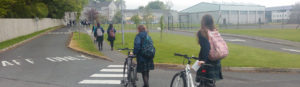 Ursuline College pupils pushing bicycles up to the school